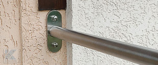 gebogener Handlauf mit Edelstahl Boden- und Wandplatte montiert